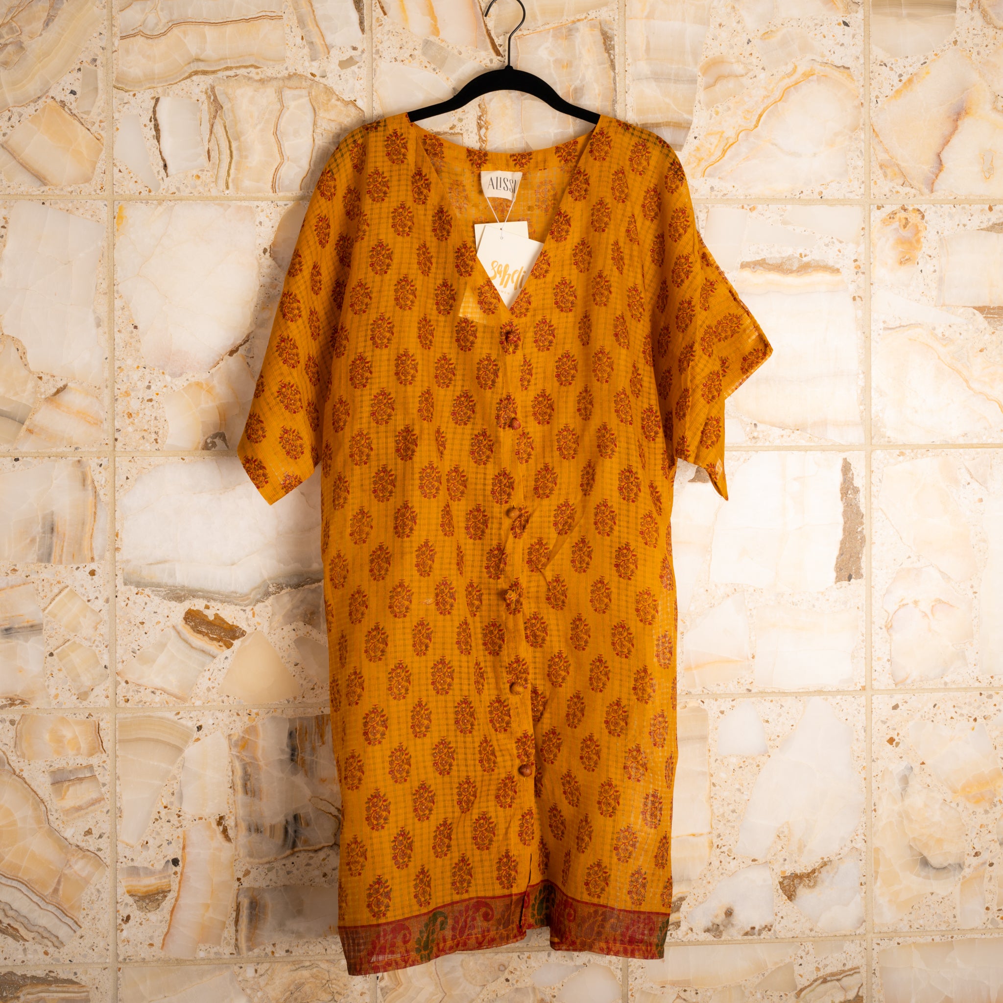 A wardrobe essential that works as a dress, shirt, duster, beach coverup, robe or nighty, and gives back to the women who make them by hand.  Made from upcycled saris; fabric content unknown.